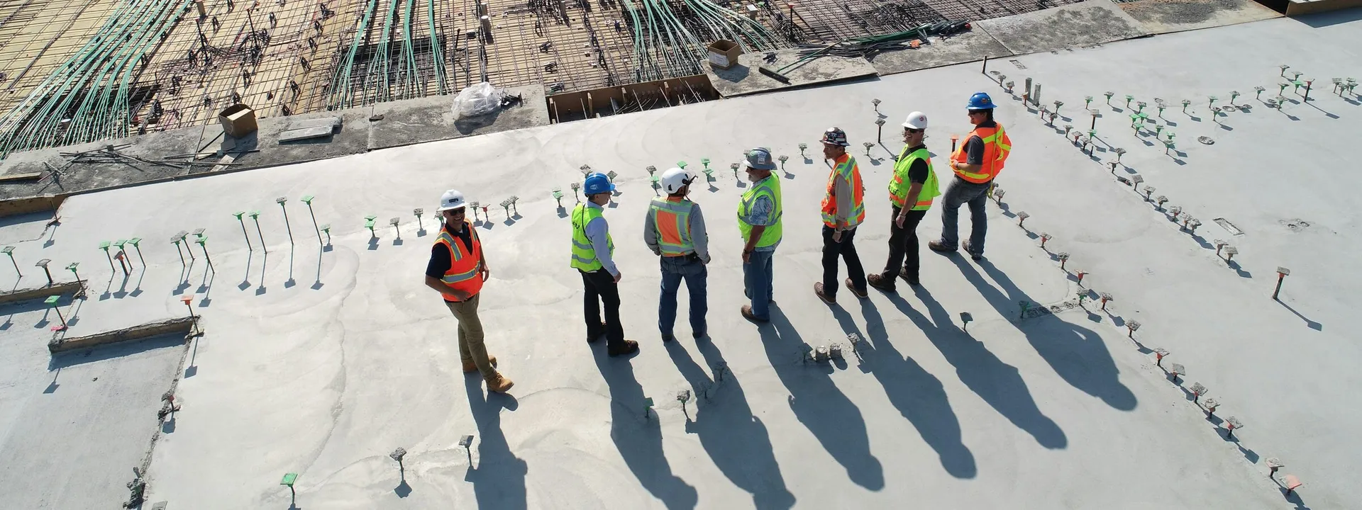 Construction crew in safety gear reviewing an active building site