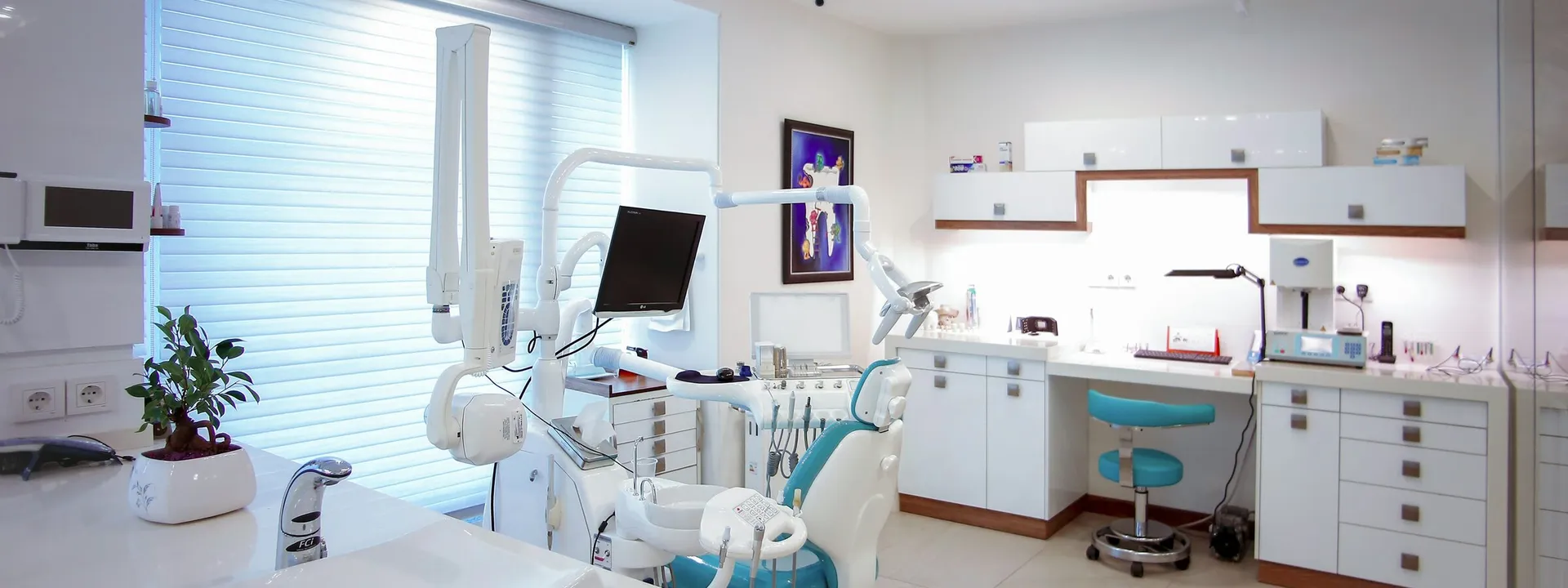 Modern outpatient clinic treatment room with exam chair and cabinetry